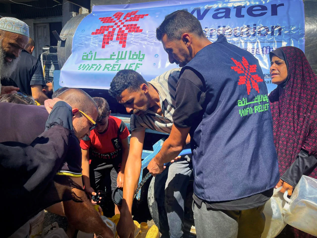 Yafa Relief volunteers distributing water to displaced families in Gaza.